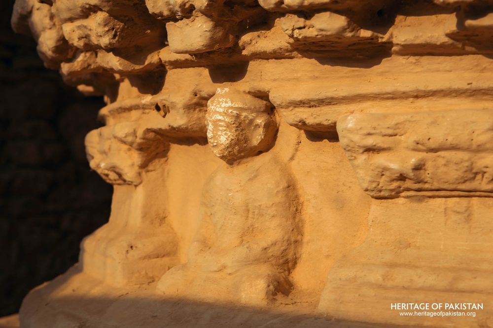 Stucco figure carved into ancient monastery stone wall.